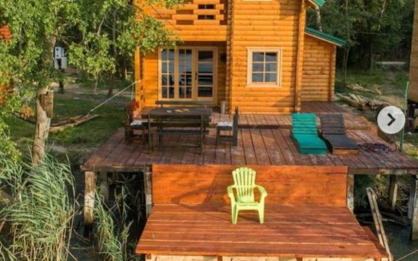 Two-storey wooden house with large terrace on riverbank in Ada Bojana