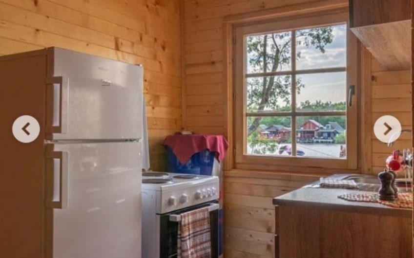 Two-storey wooden house with large terrace on riverbank in Ada Bojana
