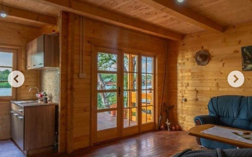 Two-storey wooden house with large terrace on riverbank in Ada Bojana