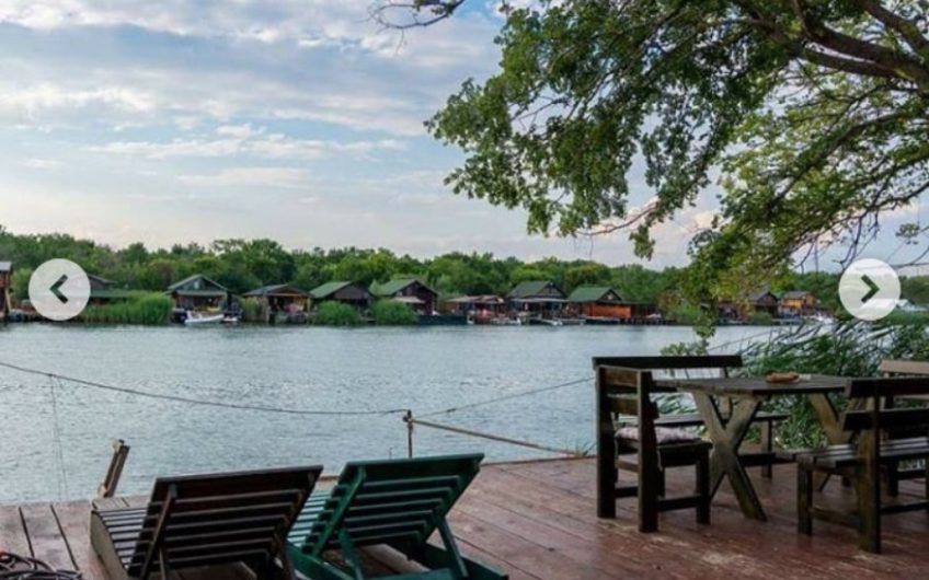 Two-storey wooden house with large terrace on riverbank in Ada Bojana